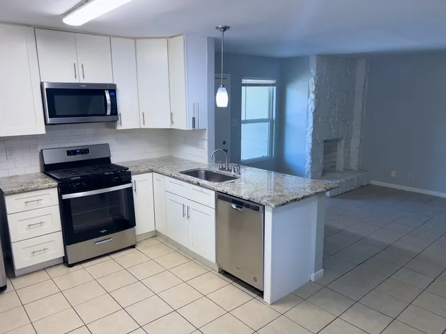 a kitchen with a refrigerator a stove a sink and a counter top space