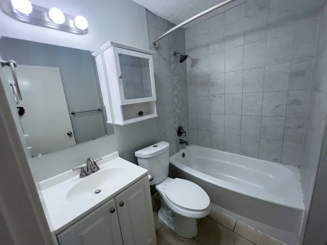 an empty room with windows and ceiling fan