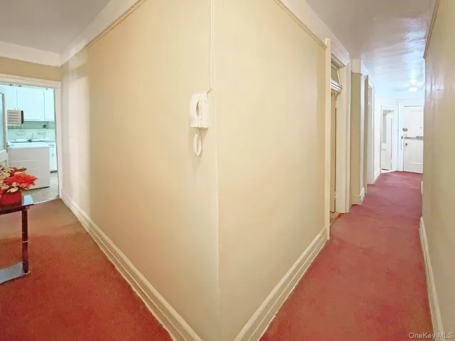a view of a hallway with closet and wooden floor