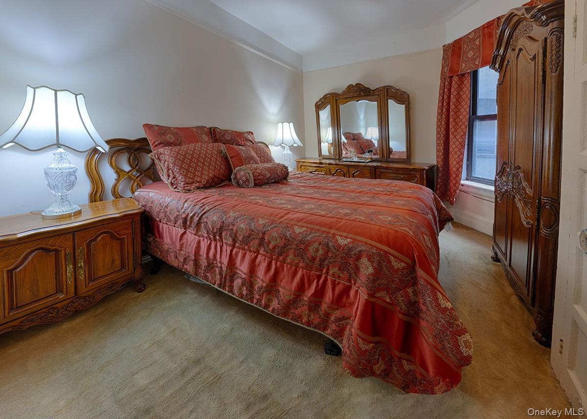 137 West 142nd Street, Unit 2D 2D Manhattan, NY 10030 - Photo 6 of 8 a bedroom with a bed a mirror and dresser