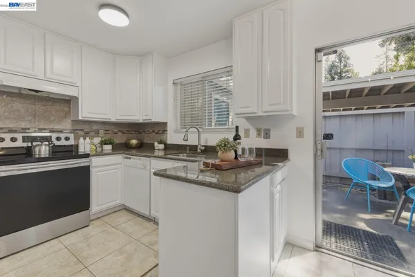 a kitchen with stainless steel appliances granite countertop a sink and a white cabinets