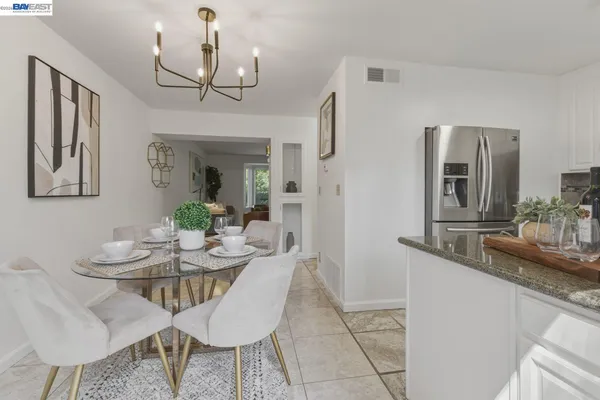 a dining room with wooden floor a chandelier a wooden table and chairs