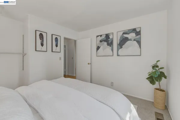 a bedroom with a large bed and a potted plant
