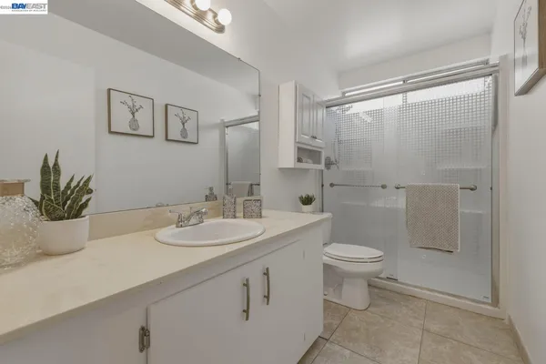 a bathroom with a granite countertop sink a toilet and a mirror