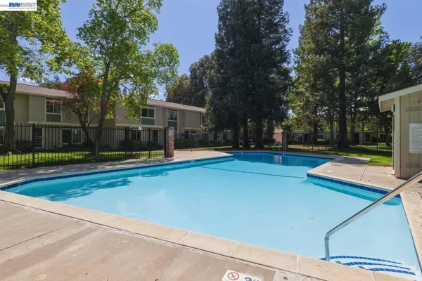 a view of a tennis ground with large trees