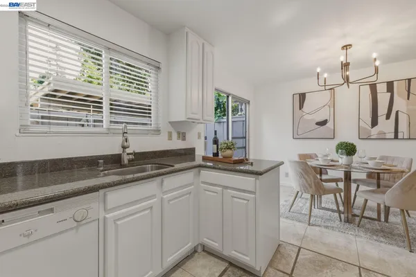 a kitchen with granite countertop a sink and white cabinets