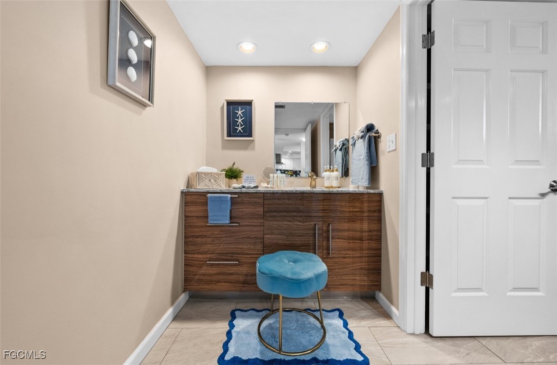 413 Augusta Boulevard, Unit 302 Naples, FL 34113 - Photo 12 of 22 a bathroom with a sink and a mirror