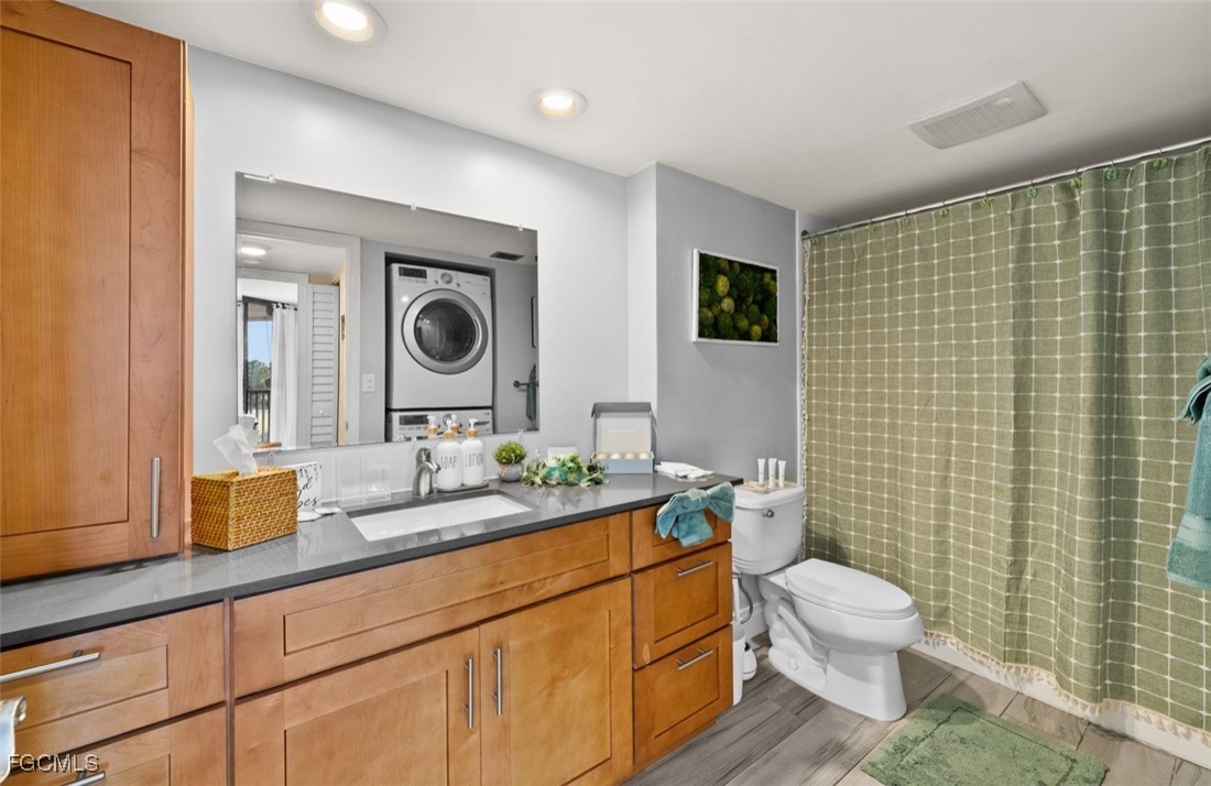 413 Augusta Boulevard, Unit 302 Naples, FL 34113 - Photo 15 of 22 a bathroom with a toilet a sink and mirror
