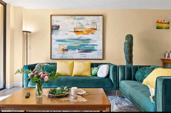 a living room with furniture flowerpot and wooden floor