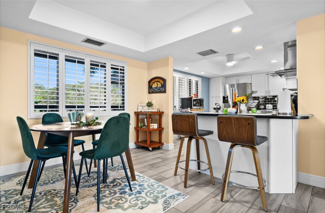 413 Augusta Boulevard, Unit 302 Naples, FL 34113 - Photo 5 of 22 a view of a dining room with furniture window and wooden floor