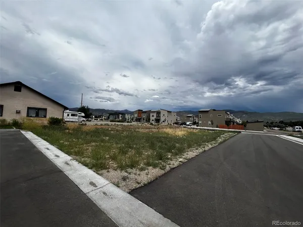 a view of a house with a yard and a large parking space