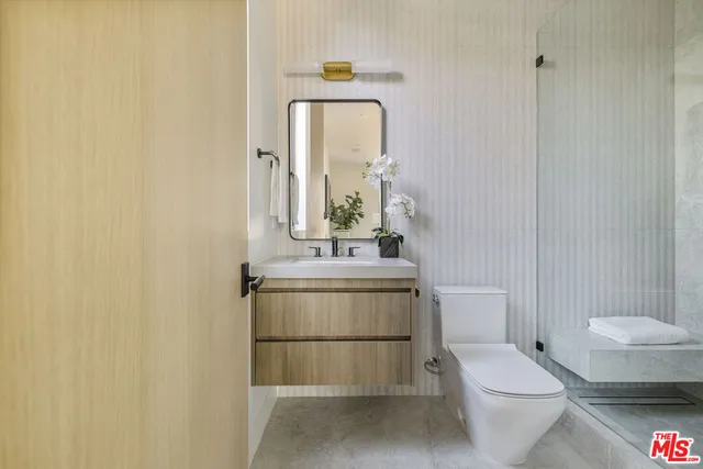 a bathroom with a toilet a sink and mirror