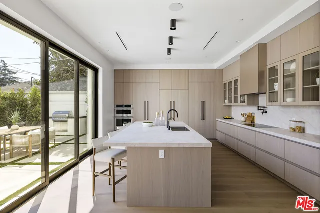 a kitchen with kitchen island a large window in it