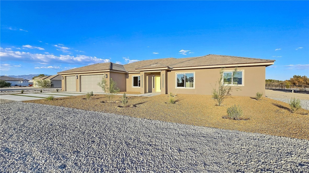 1120 West Gamebird Road Pahrump, NV 89048 - Photo 1 of 36 Ranch-style house featuring stucco siding, concrete driveway, and an attached garage
