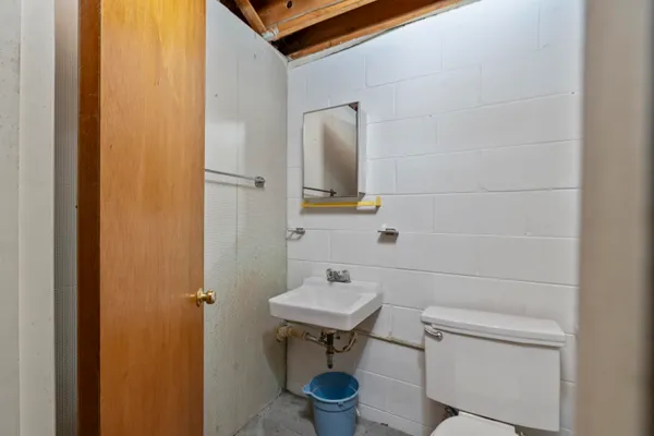 a bathroom with a sink a toilet and mirror