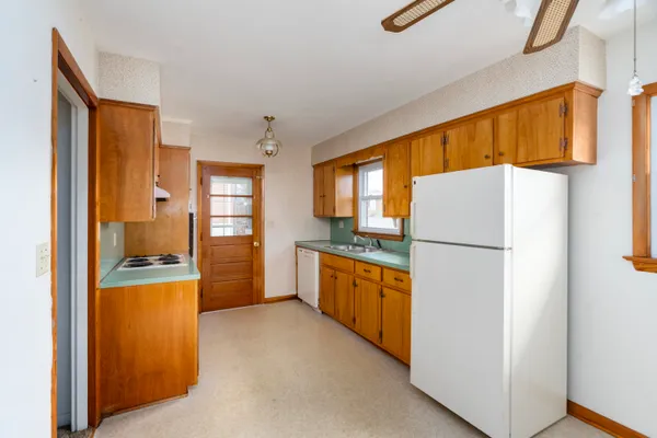 a kitchen with a refrigerator a stove top oven a washer dryer and appliances
