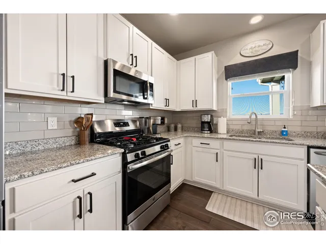 a kitchen with stainless steel appliances granite countertop a sink a stove a microwave and cabinets
