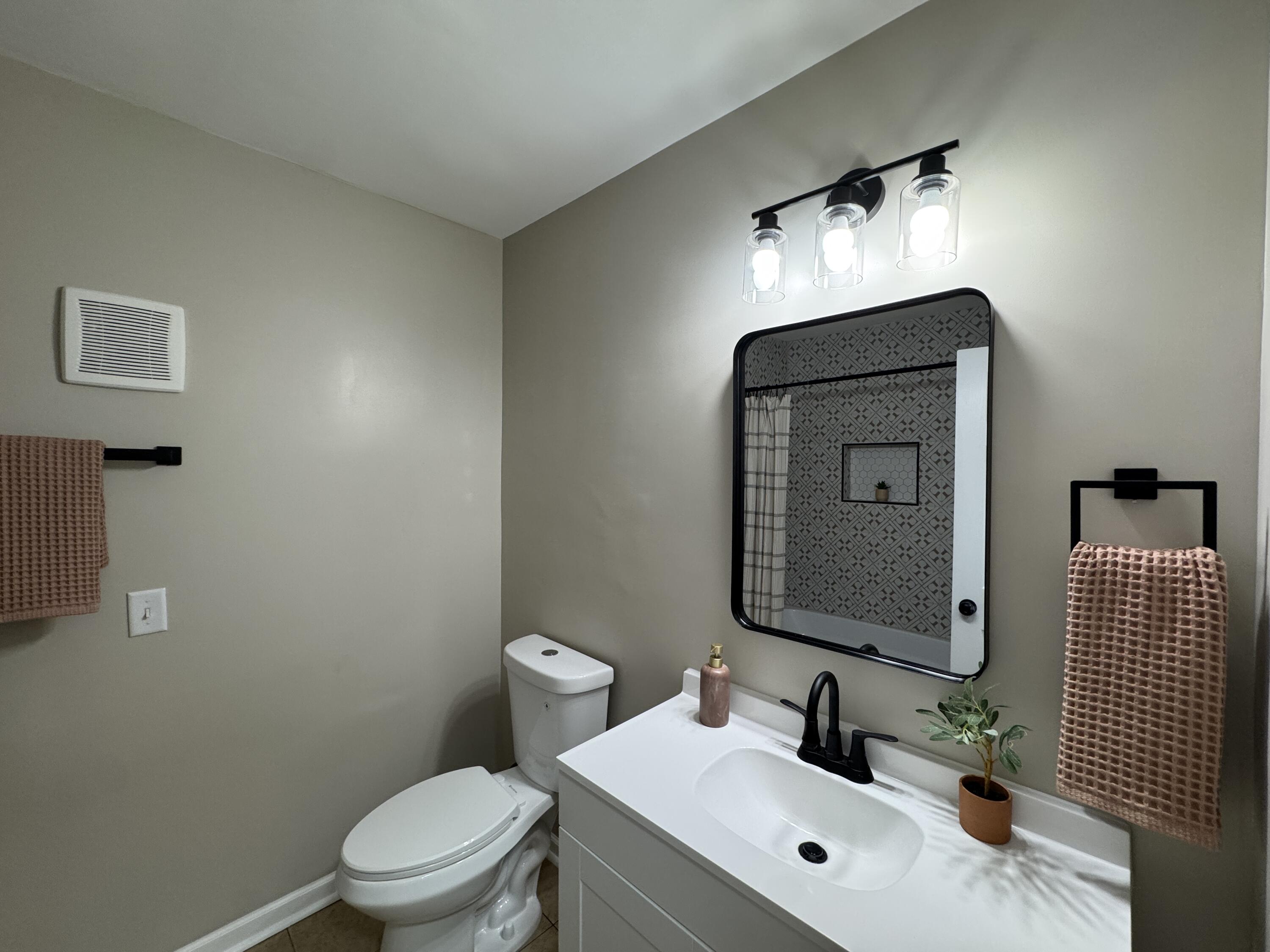 656 Montgomery Street Gary, IN 46403 - Photo 11 of 31 a bathroom with a toilet sink and mirror