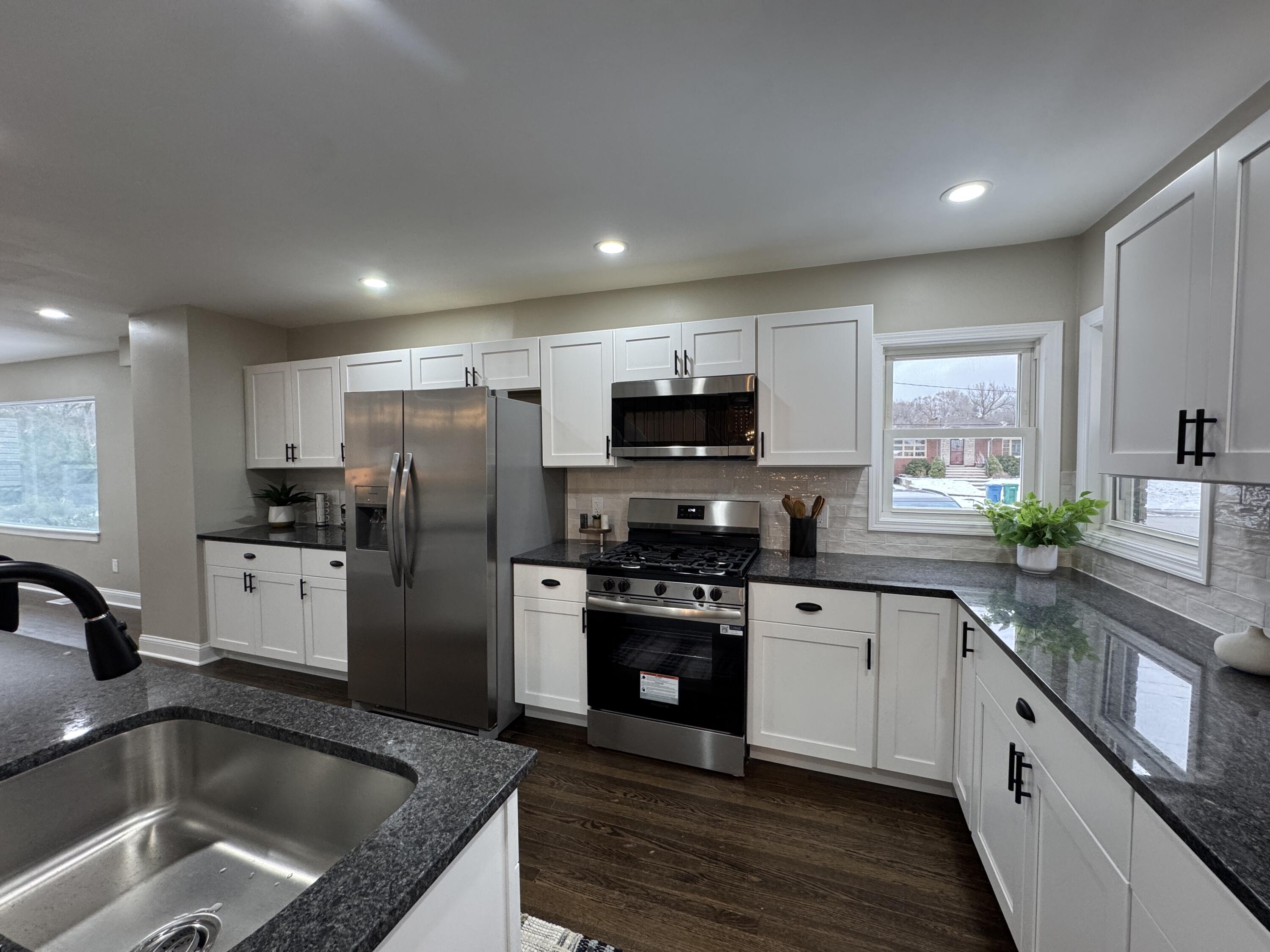 656 Montgomery Street Gary, IN 46403 - Photo 7 of 31 a kitchen with refrigerator a sink and white cabinets