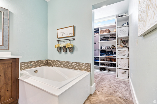 580 Cherry Ridge Lane Richmond, UT 84333 - Photo 22 of 53 Full bathroom with a garden tub, vanity, parquet flooring, and a spacious closet