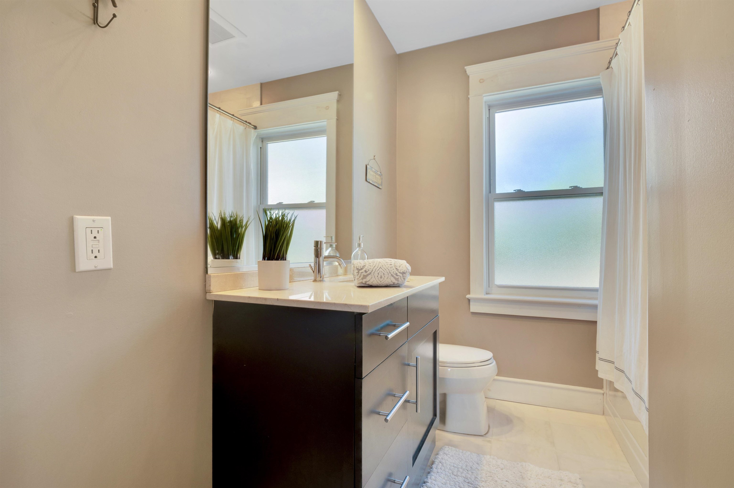 96 Commonwealth Avenue Strathmere, NJ 08248 - Photo 13 of 37 a bathroom with a toilet a sink a mirror and a window