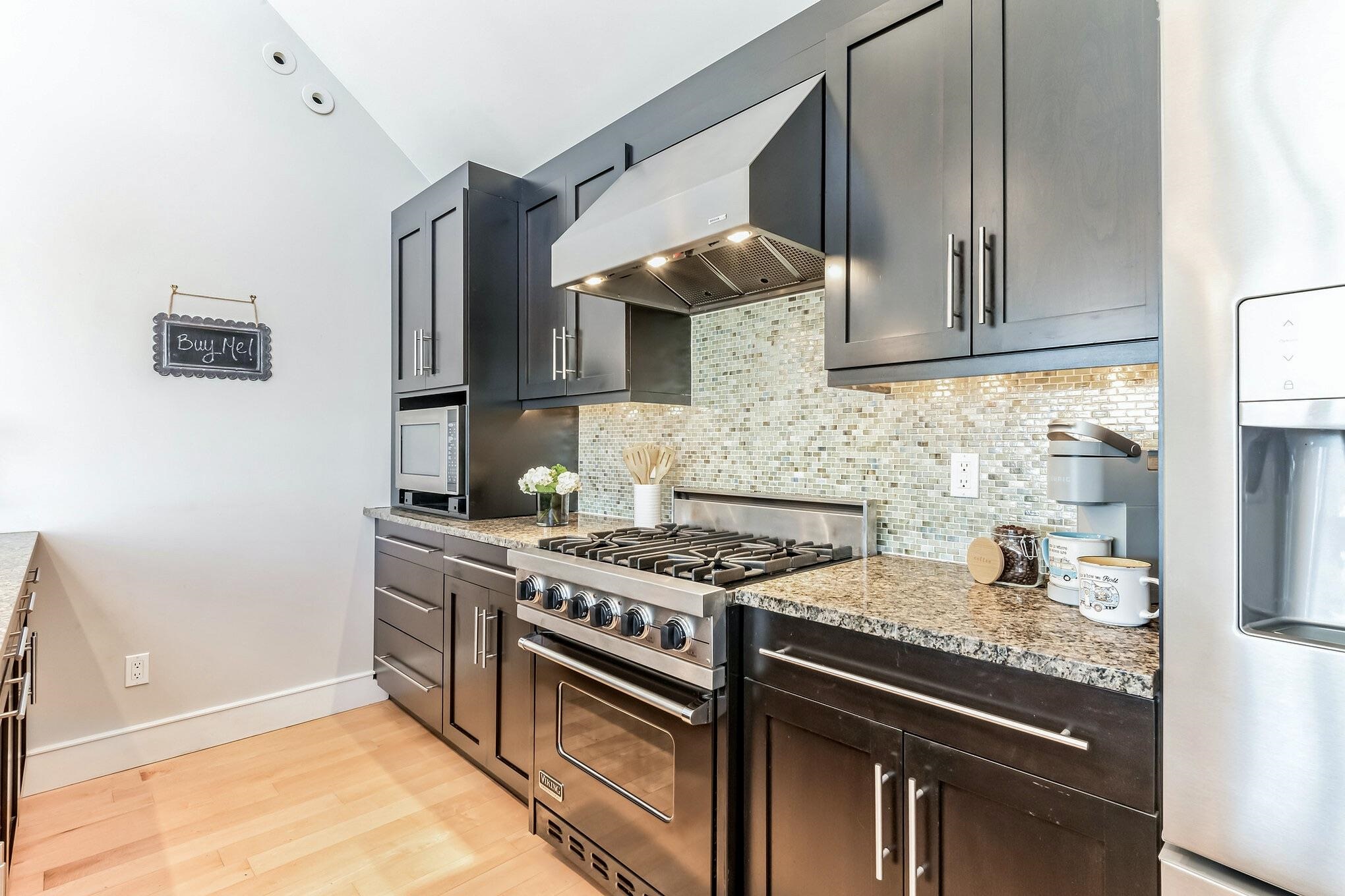 96 Commonwealth Avenue Strathmere, NJ 08248 - Photo 5 of 37 a kitchen with stainless steel appliances a stove a sink and a microwave