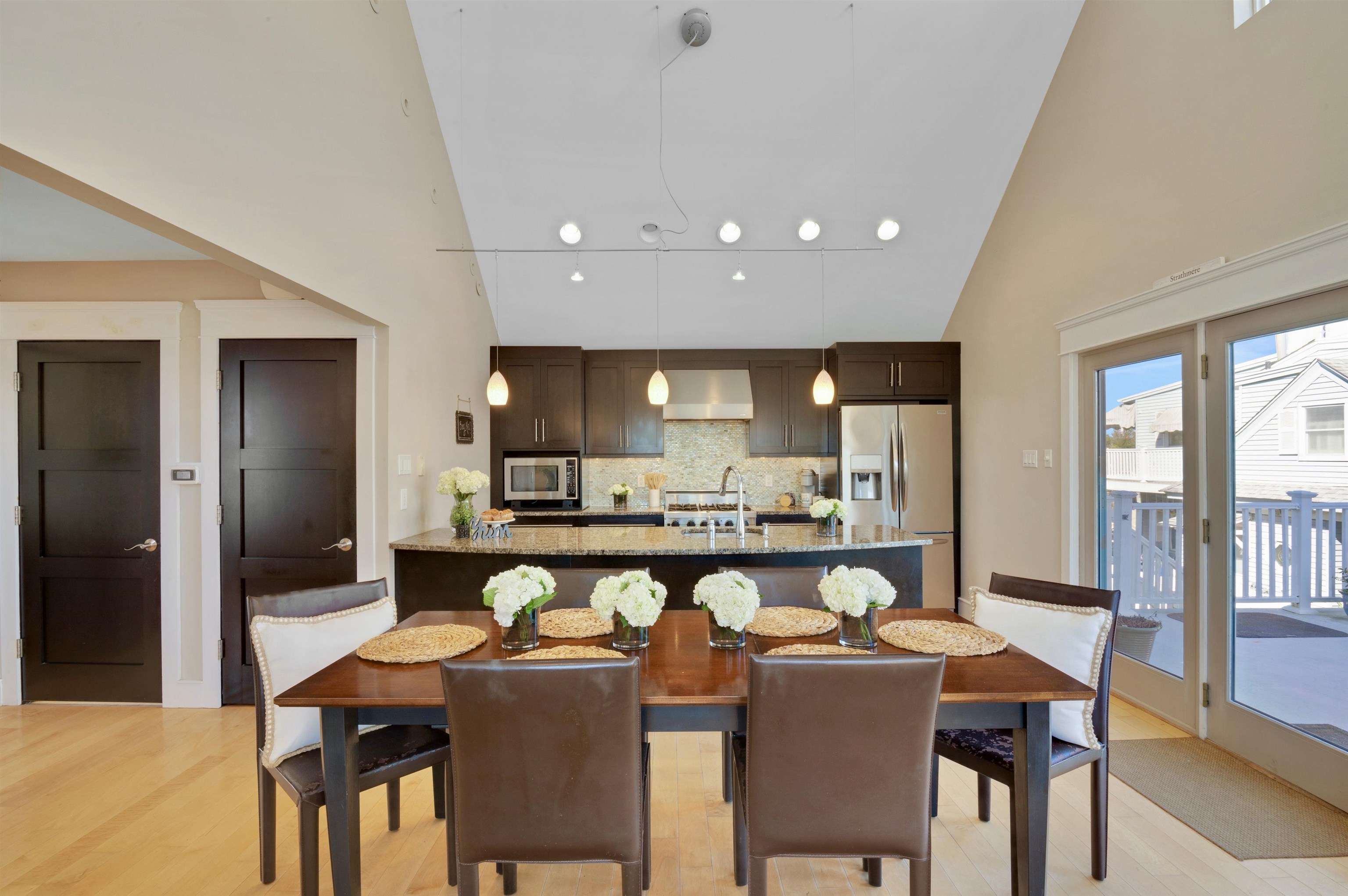 96 Commonwealth Avenue Strathmere, NJ 08248 - Photo 9 of 37 a dining room with stainless steel appliances kitchen island granite countertop a dining table chairs and a refrigerator