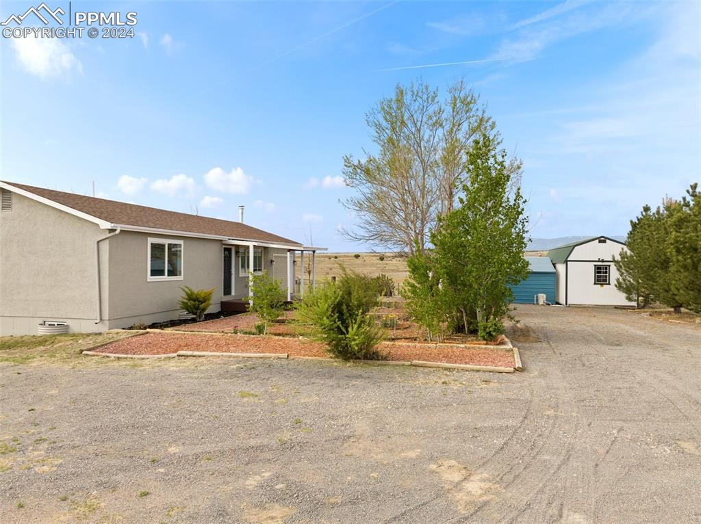 a view of a house with backyard and a tree