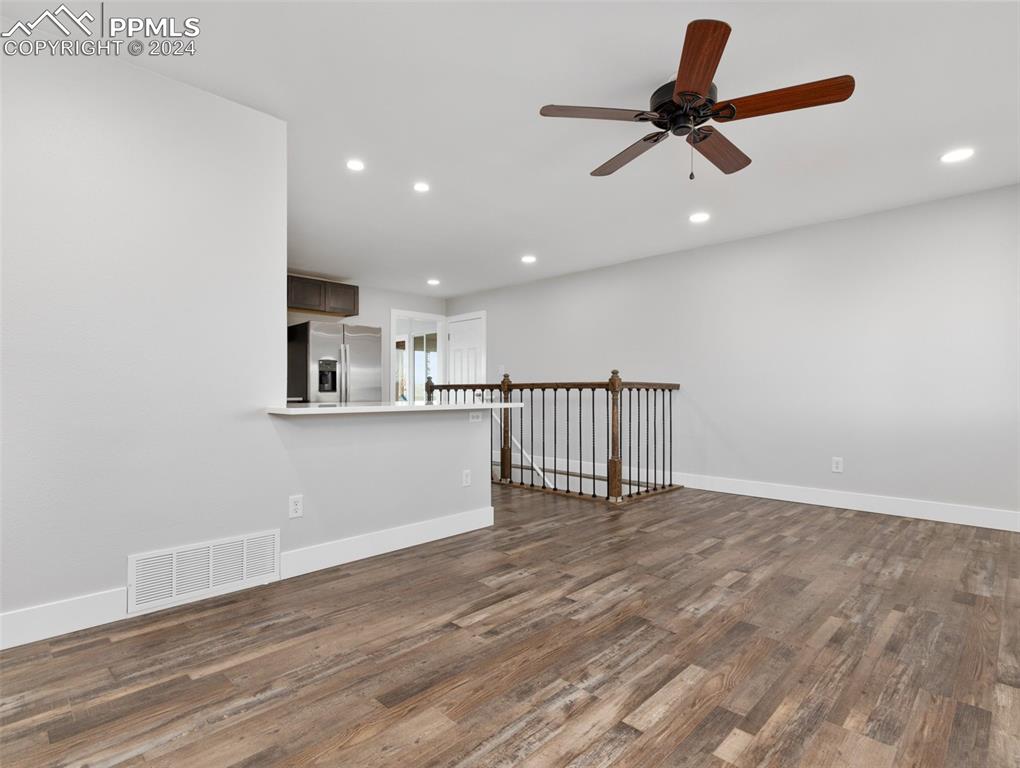 6455 Galbreth Road Pueblo, CO 81005 - Photo 12 of 37 a view of a livingroom with a ceiling fan & wooden floor