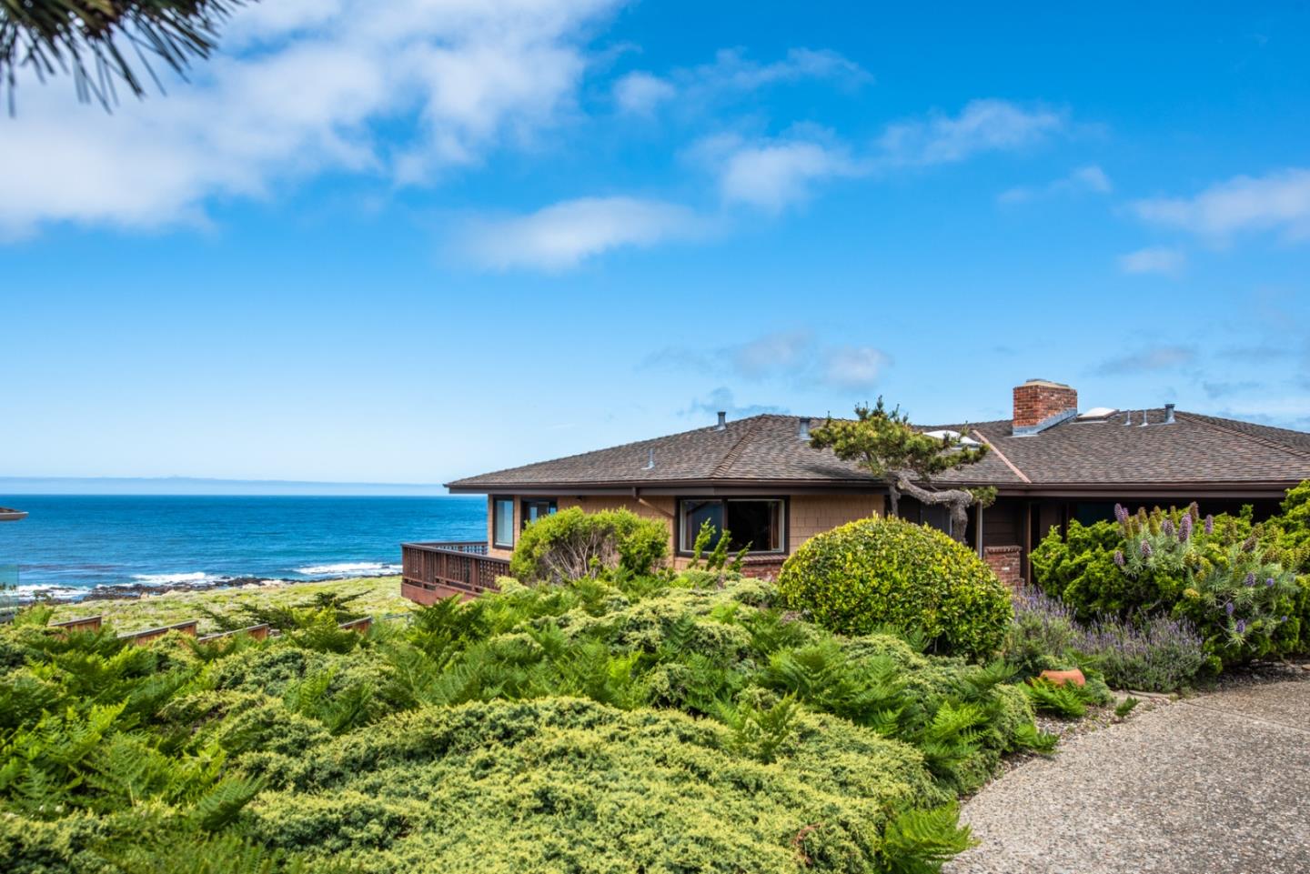2715 Ribera Road Carmel, CA 93923 - Photo 2 of 14 a view of a table and chairs under an umbrella in front of house