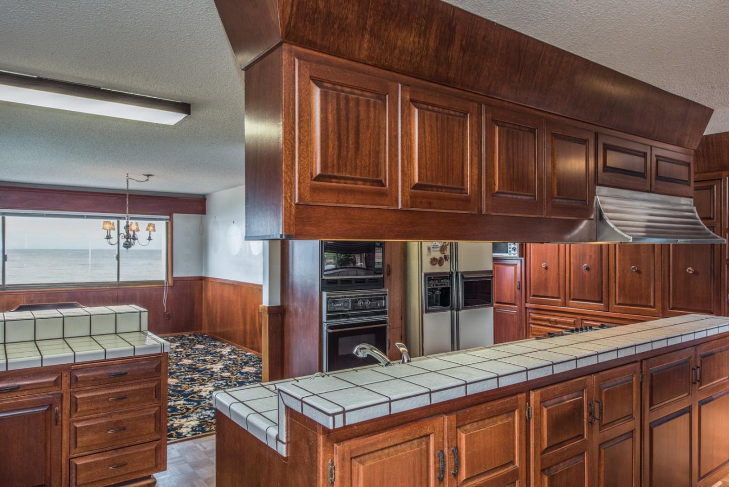2715 Ribera Road Carmel, CA 93923 - Photo 9 of 14 a kitchen view of a kitchen island wooden cabinets and floor to ceiling window