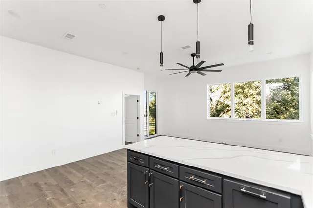 an empty room with wooden floor closet and windows
