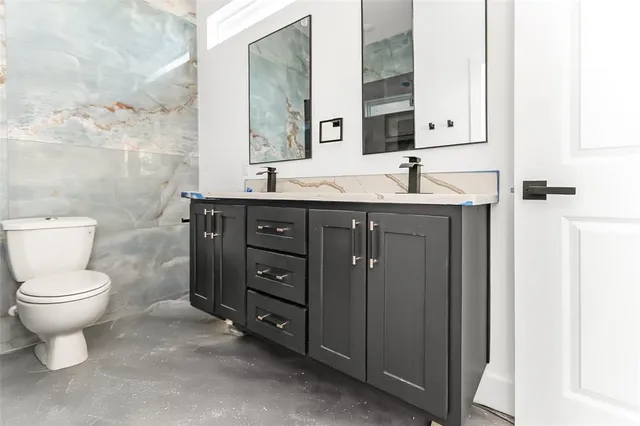 a bathroom with double vanity and a tub
