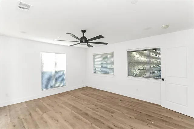 a view of empty room with wooden floor