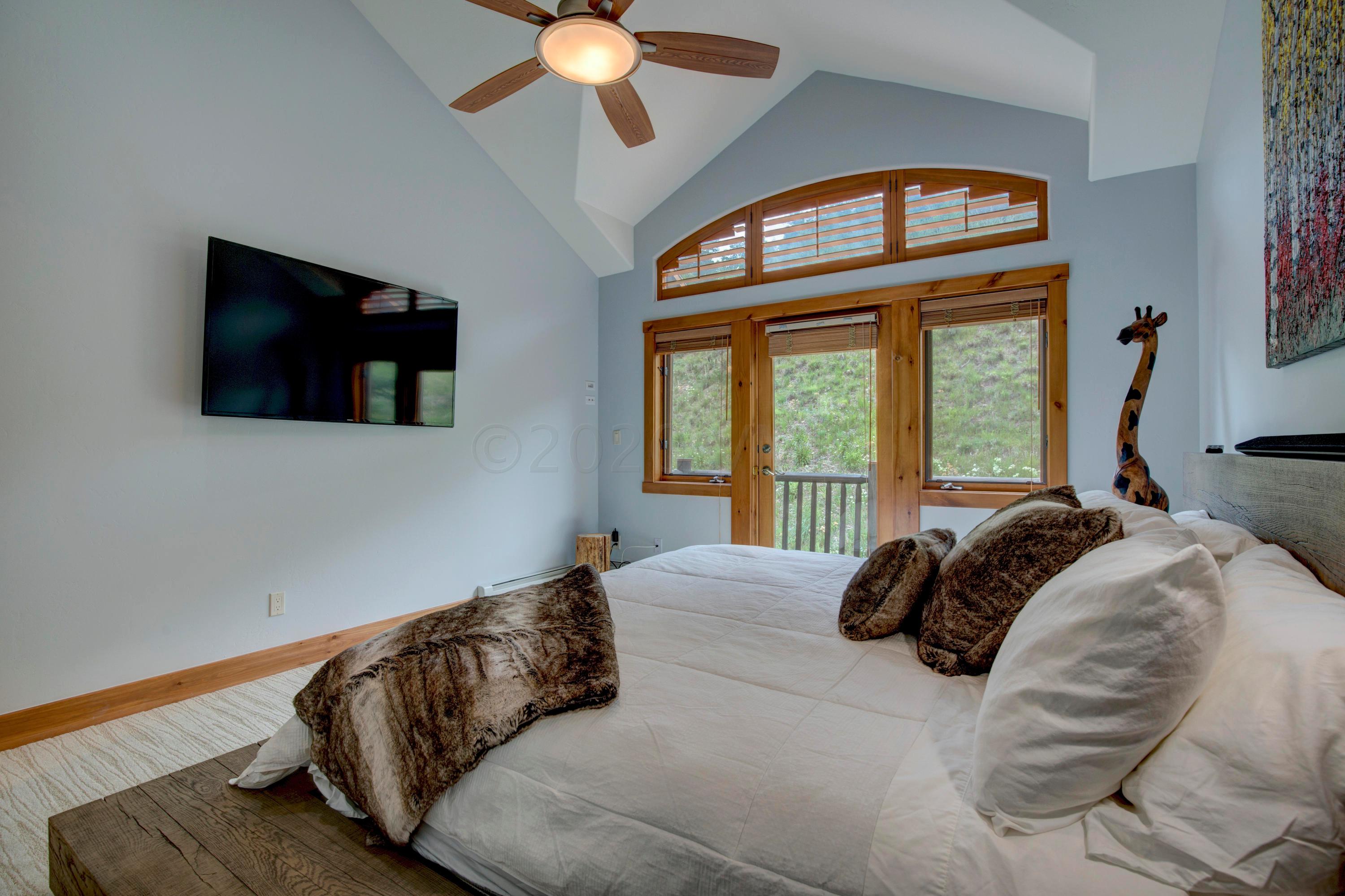 92 Knudson Ranch Road Edwards, CO 81632 - Photo 13 of 26 a bedroom with a bed and a flat tv screen on dresser