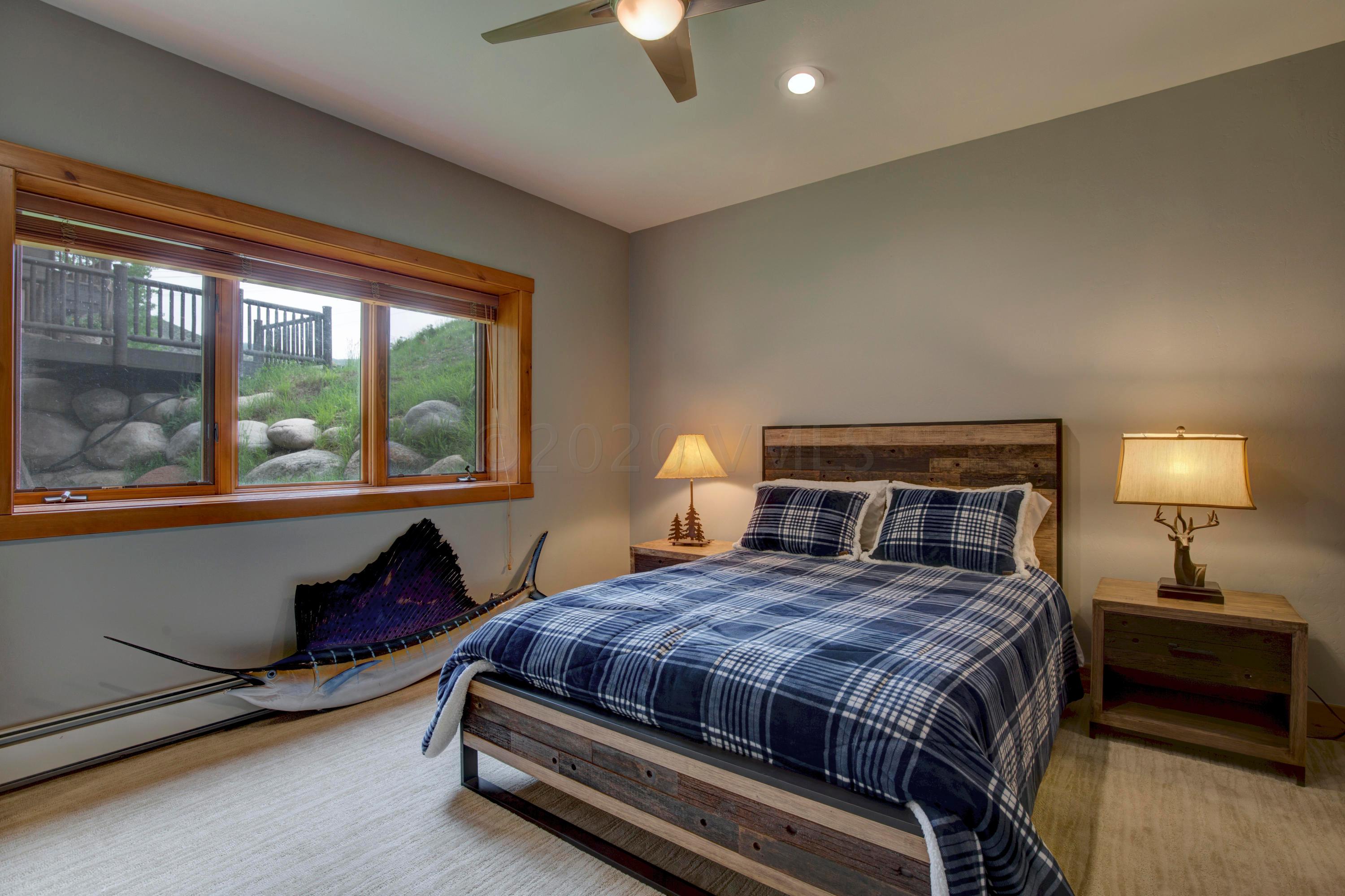 92 Knudson Ranch Road Edwards, CO 81632 - Photo 22 of 26 a bedroom with a bed and a lamp next to a window
