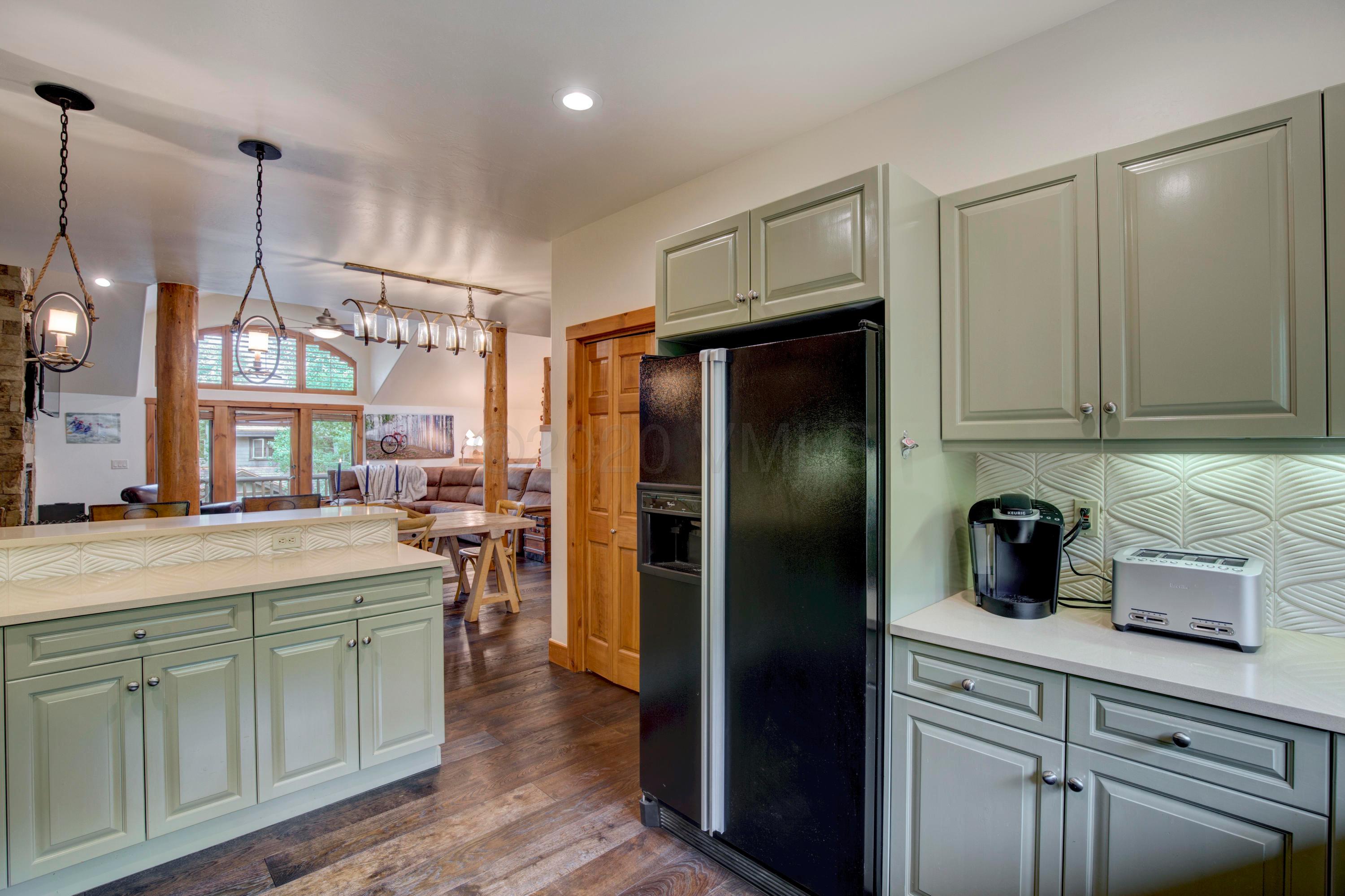 92 Knudson Ranch Road Edwards, CO 81632 - Photo 10 of 26 a kitchen with white cabinets and stainless steel appliances