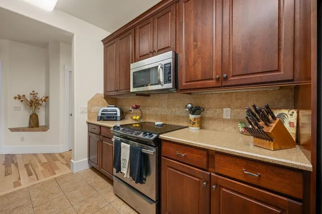 a kitchen with stainless steel appliances granite countertop a sink stove and microwave