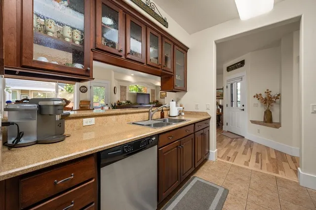 a kitchen with stainless steel appliances granite countertop a sink and dishwasher a oven with wooden cabinets