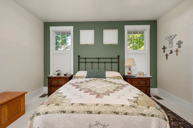 a bed sitting in a bedroom next to a window