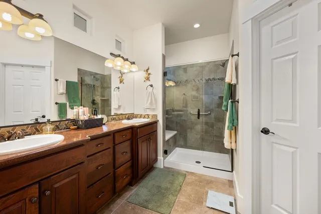 a bathroom with a double vanity sink mirror double shower and a bathtub