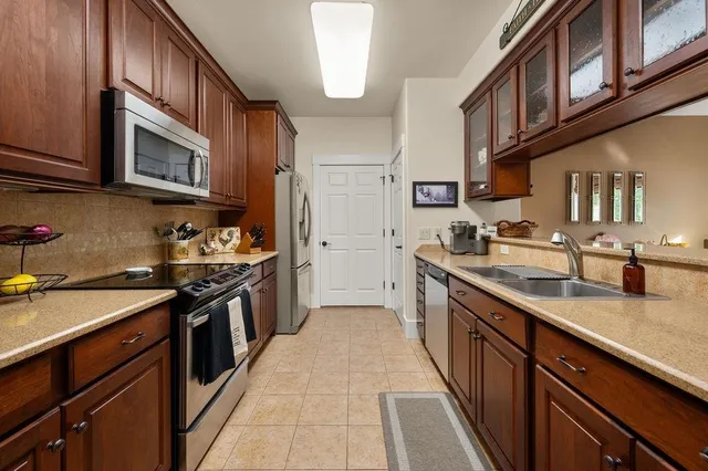 a kitchen with stainless steel appliances granite countertop a stove a sink dishwasher and a refrigerator