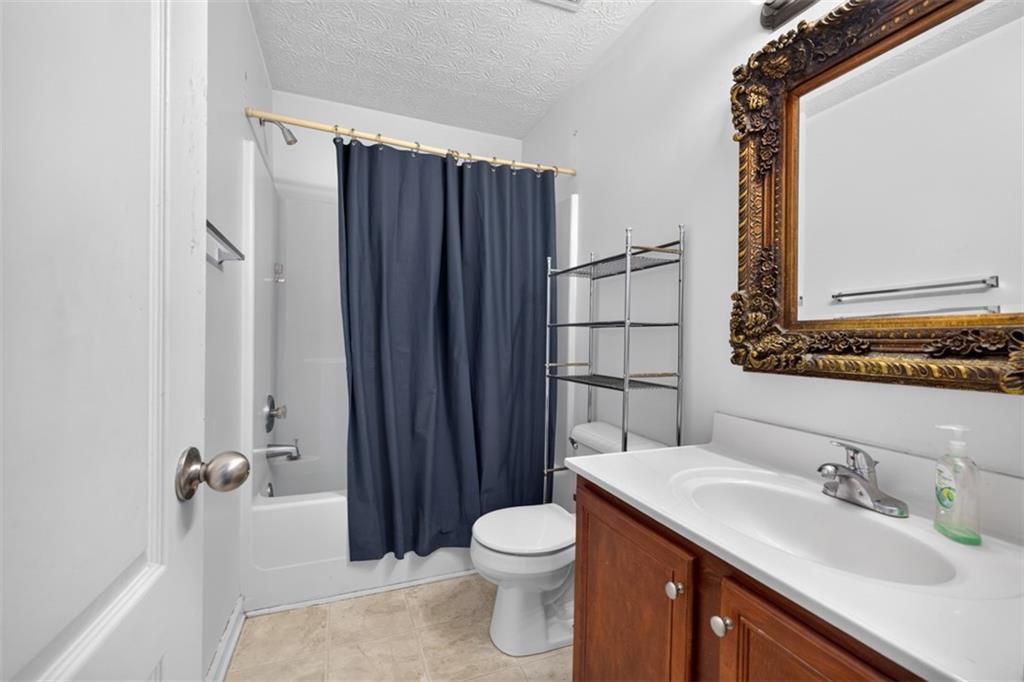 602 Pendergrass Road Winder, GA 30680 - Photo 32 of 44 a bathroom with a granite countertop sink toilet and shower