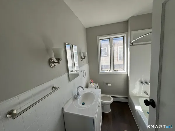a bathroom with a toilet sink and mirror