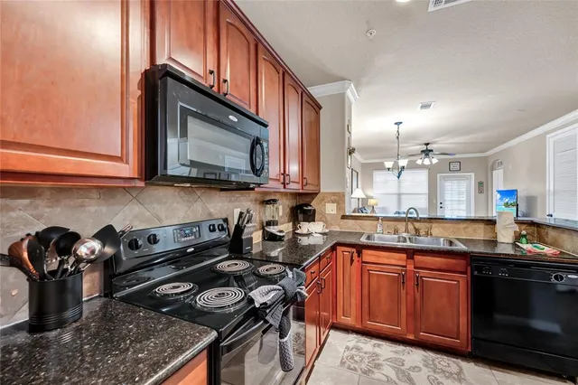 a kitchen with stainless steel appliances granite countertop a stove a sink and a microwave