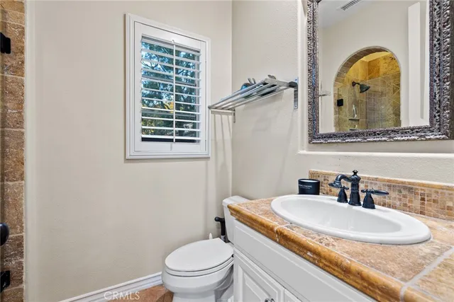a spacious bathroom with a granite countertop sink and a mirror