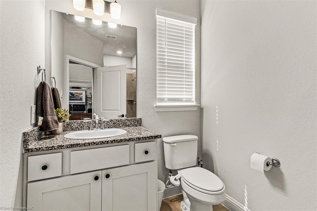 904 Vineyard Way Forney, TX 75126 - Photo 18 of 38 a bathroom with a granite countertop toilet sink and mirror