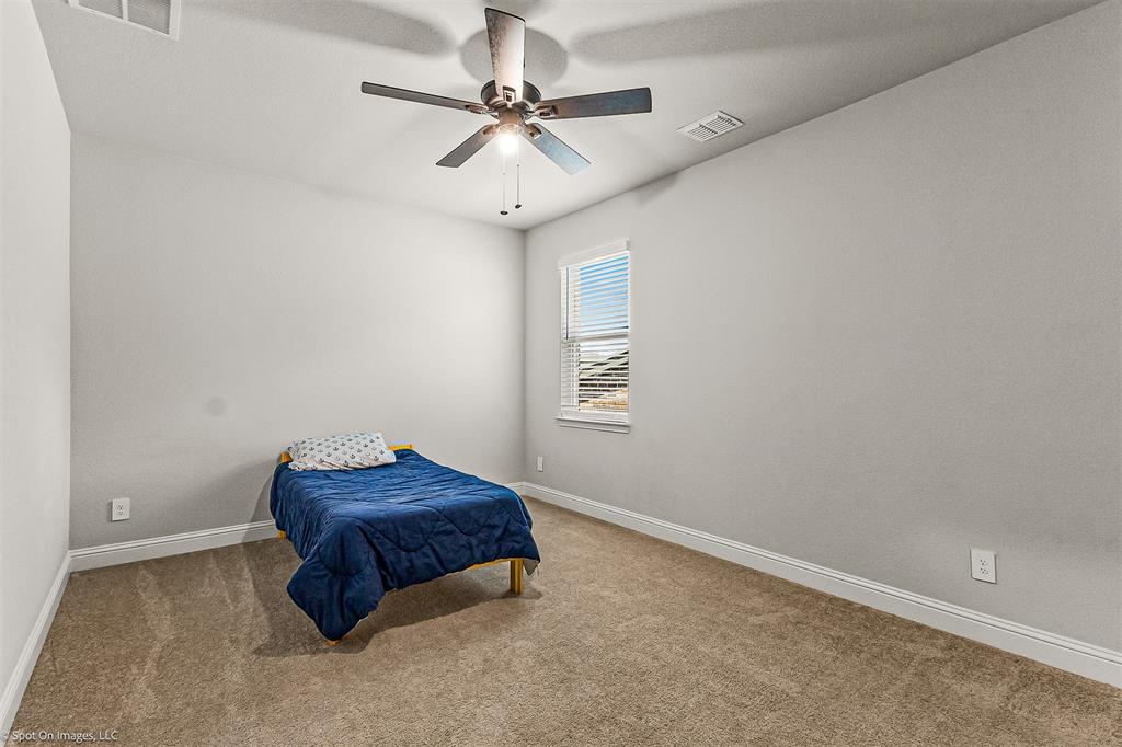 904 Vineyard Way Forney, TX 75126 - Photo 25 of 38 a room with a bed and a ceiling fan