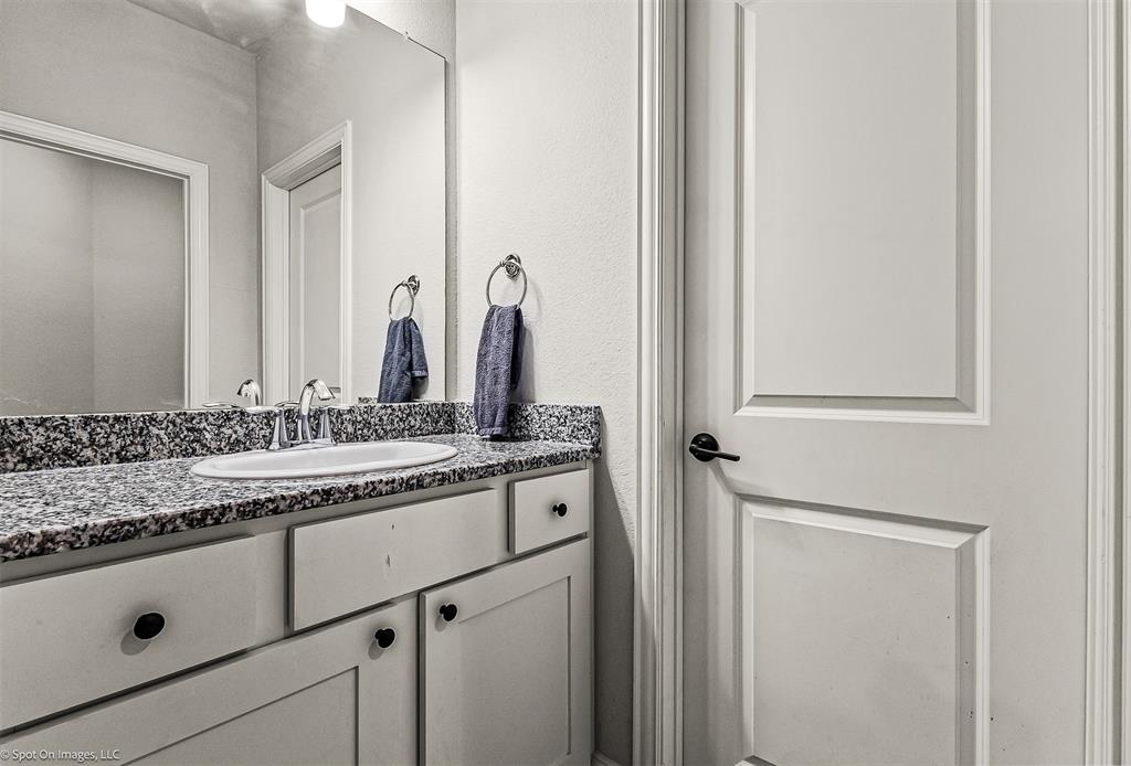 904 Vineyard Way Forney, TX 75126 - Photo 27 of 38 a bathroom with a granite countertop sink and a mirror