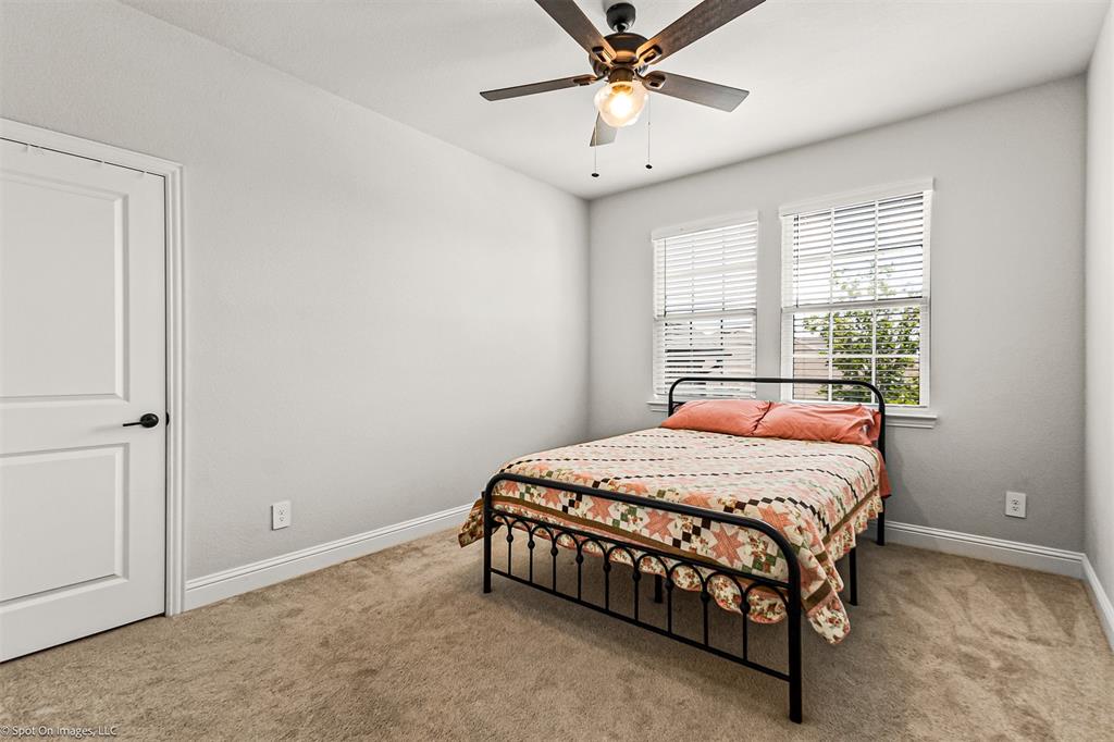 904 Vineyard Way Forney, TX 75126 - Photo 32 of 38 a bedroom with a bed and a chandelier